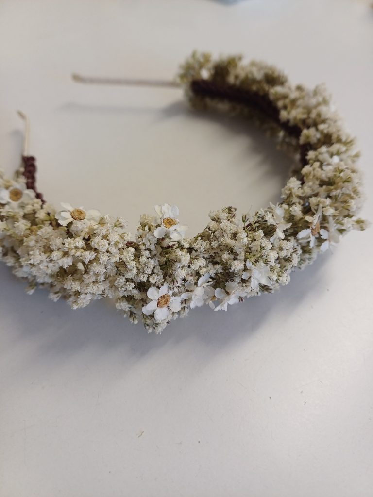 Tocado de flores sobre mesa blanca