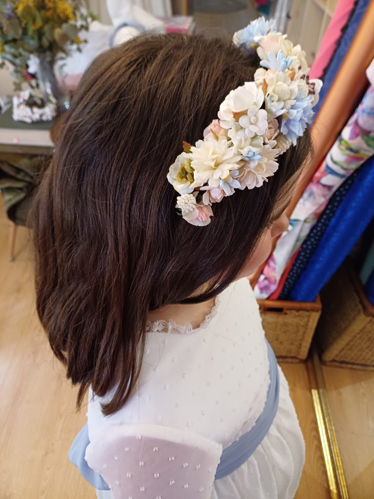 Niña con vestido de comunión y tocado de flores