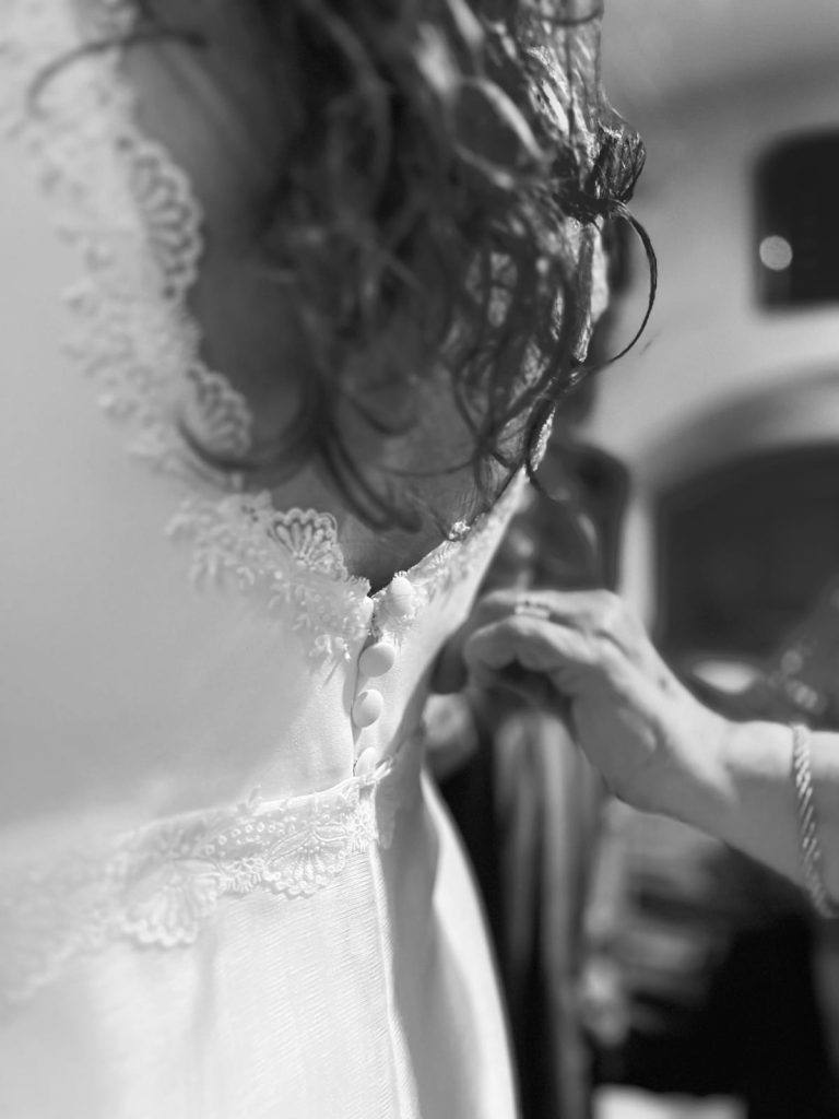 Fotografía en blanco y negro de ajustes del vestido de novia