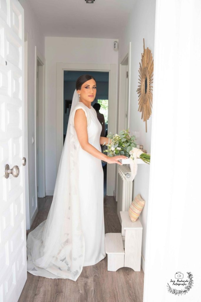 Novia con el ramillete en el interior de una casa